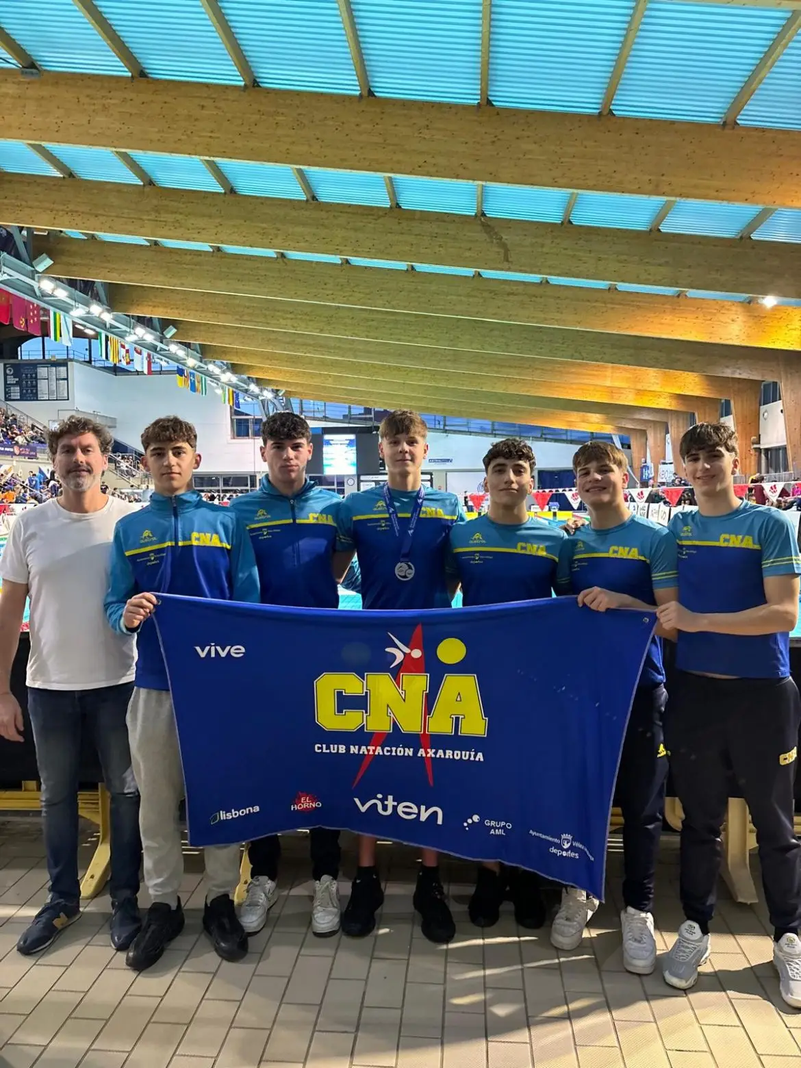 Nadadores júnior del CNA y su entrenador, en el Campeonato de España júnior de invierno 2025 en Sabadell